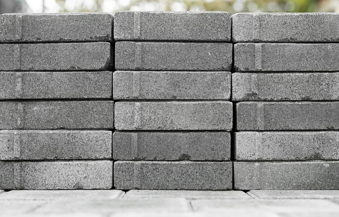 A mason setting a fly ash brick into a fresh course